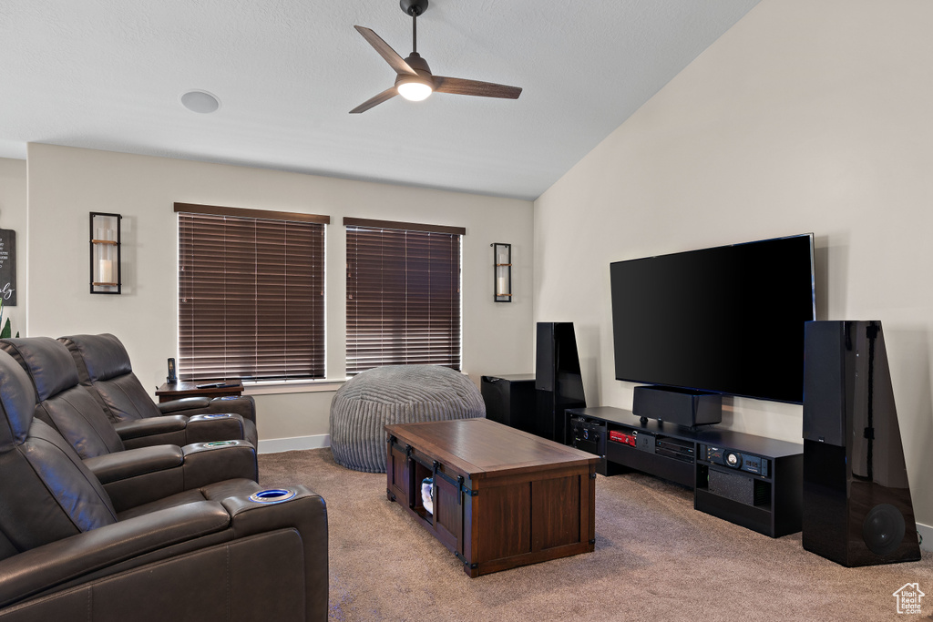 Living area with light carpet, ceiling fan, and lofted ceiling
