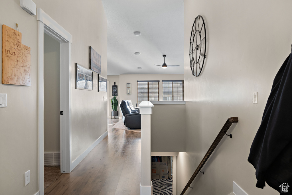Corridor featuring an upstairs landing and wood finished floors