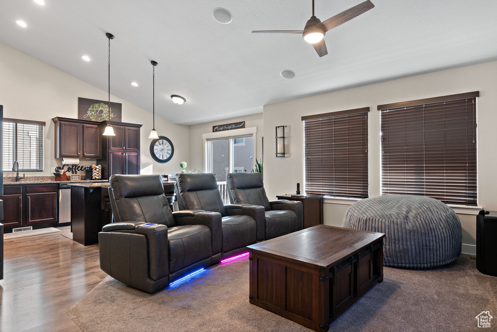 Home theater room featuring a ceiling fan, lofted ceiling, recessed lighting, and wood finished floors