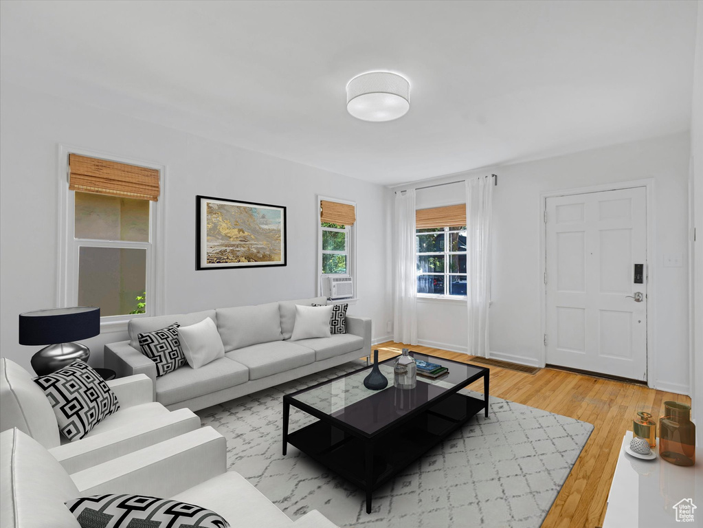 Living room with light wood-style flooring and cooling unit