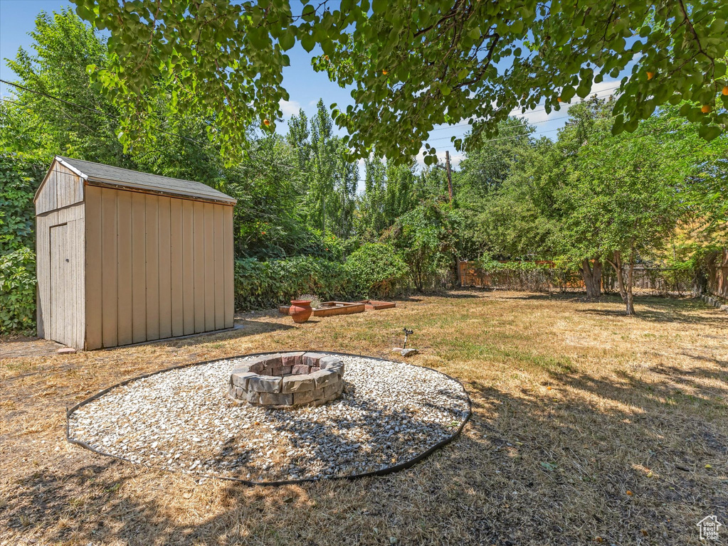View of yard featuring a fire pit and a shed