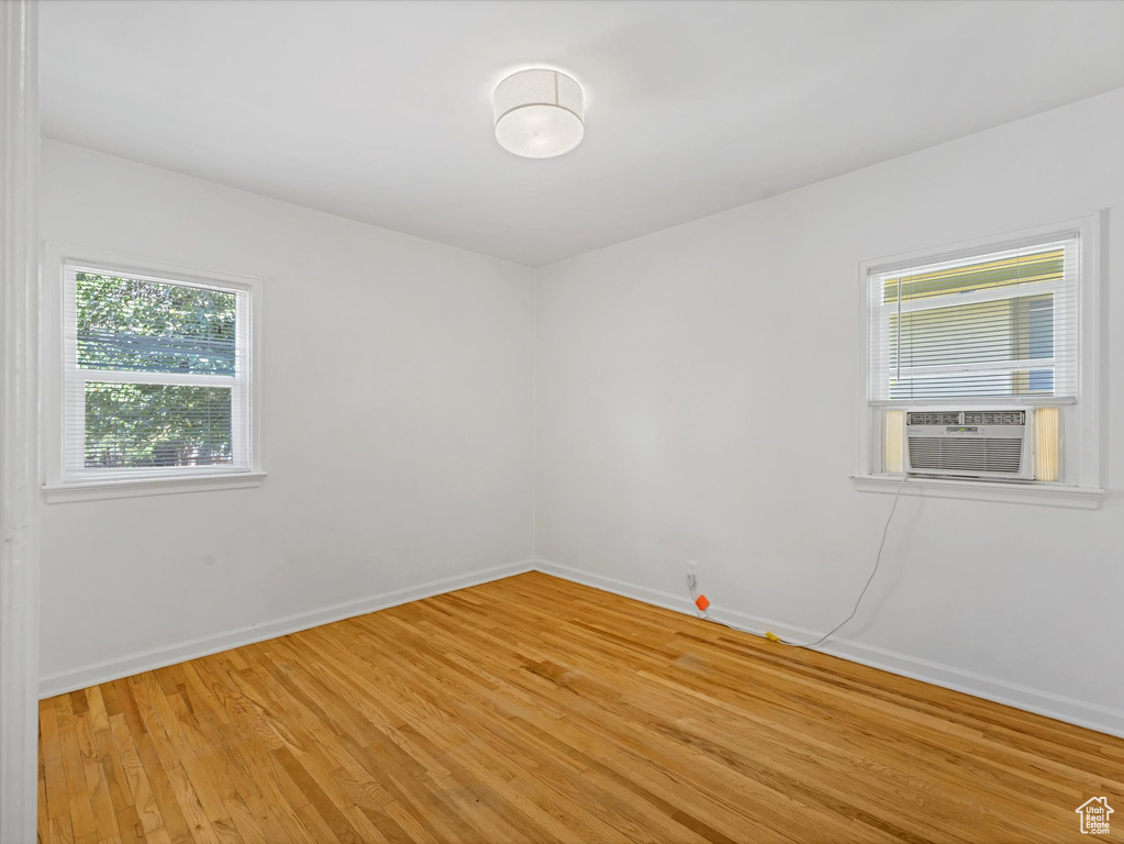 Unfurnished room with light wood-style floors and cooling unit