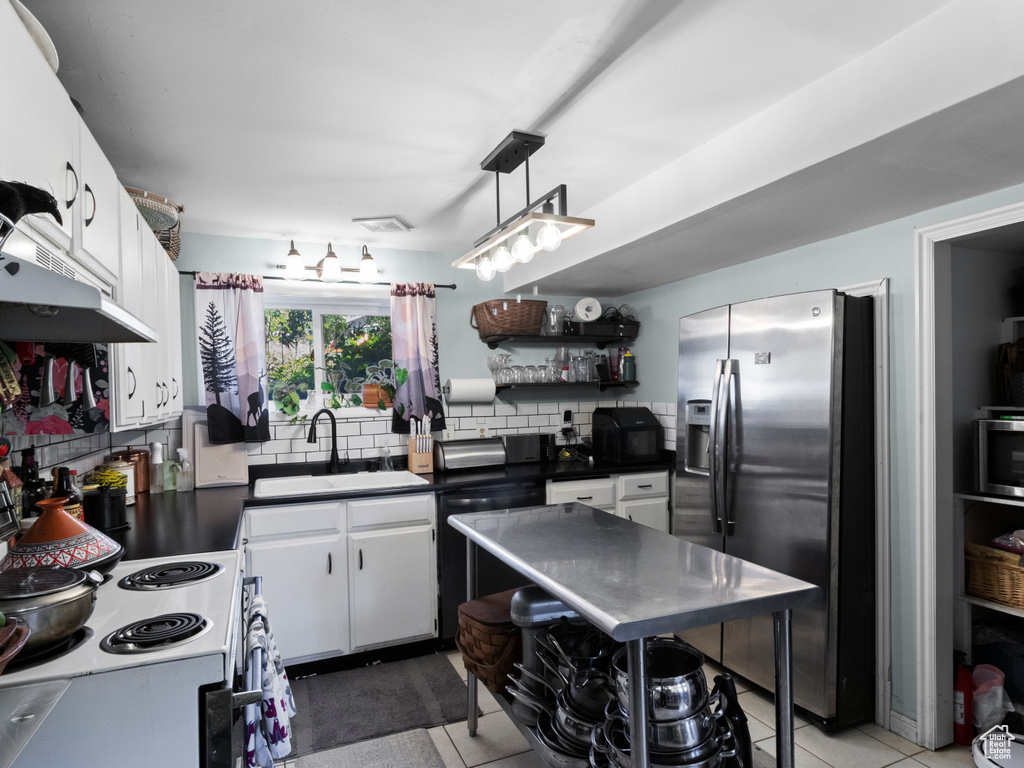 Kitchen with stainless steel fridge with ice dispenser, electric stove, open shelves, dishwasher, and dark countertops