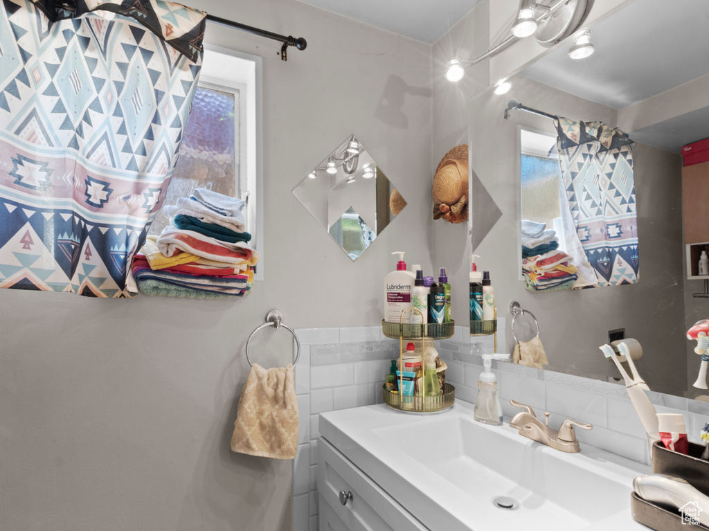 Bathroom with vanity, plenty of natural light, and tasteful backsplash