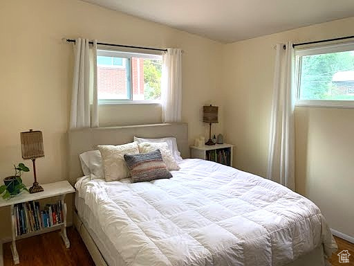 Bedroom with multiple windows and wood finished floors