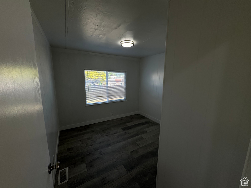 Unfurnished room with dark wood-style flooring and baseboards