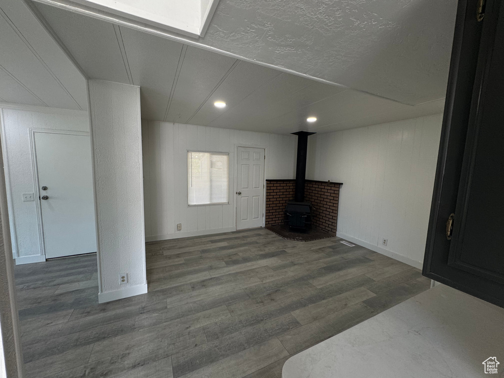 Unfurnished living room with a wood stove, wood finished floors, and recessed lighting