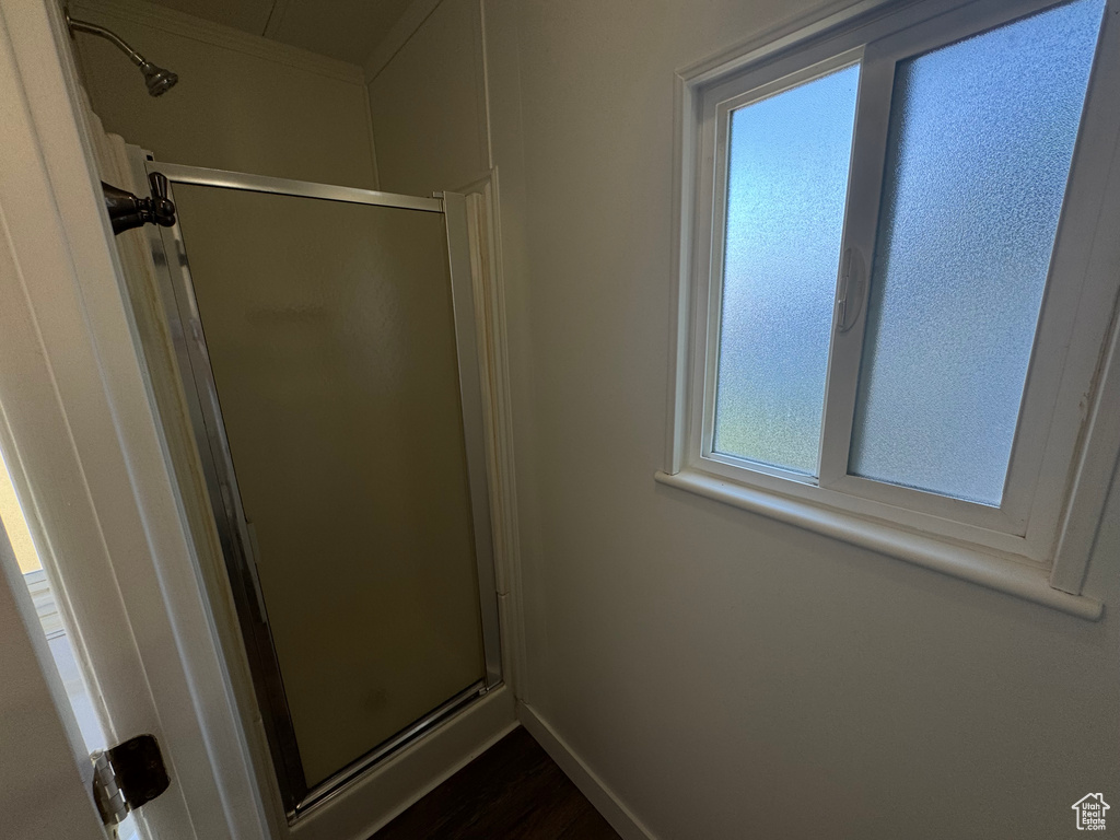 Full bath with a stall shower and wood finished floors