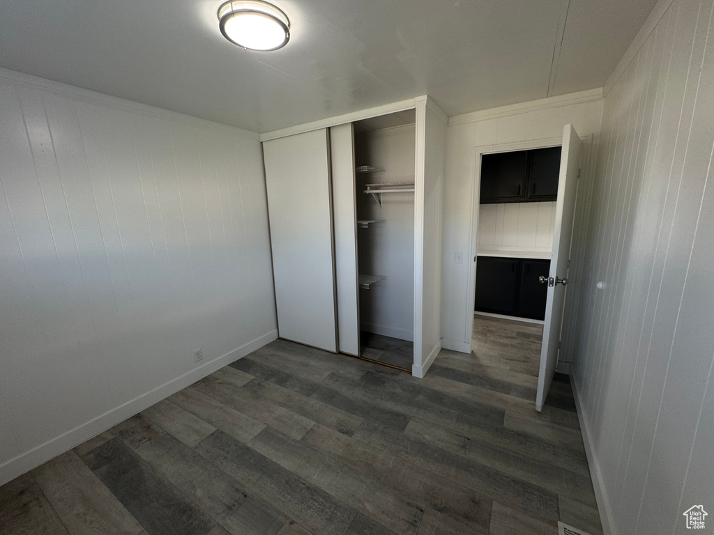 Unfurnished bedroom with wood finished floors and a closet