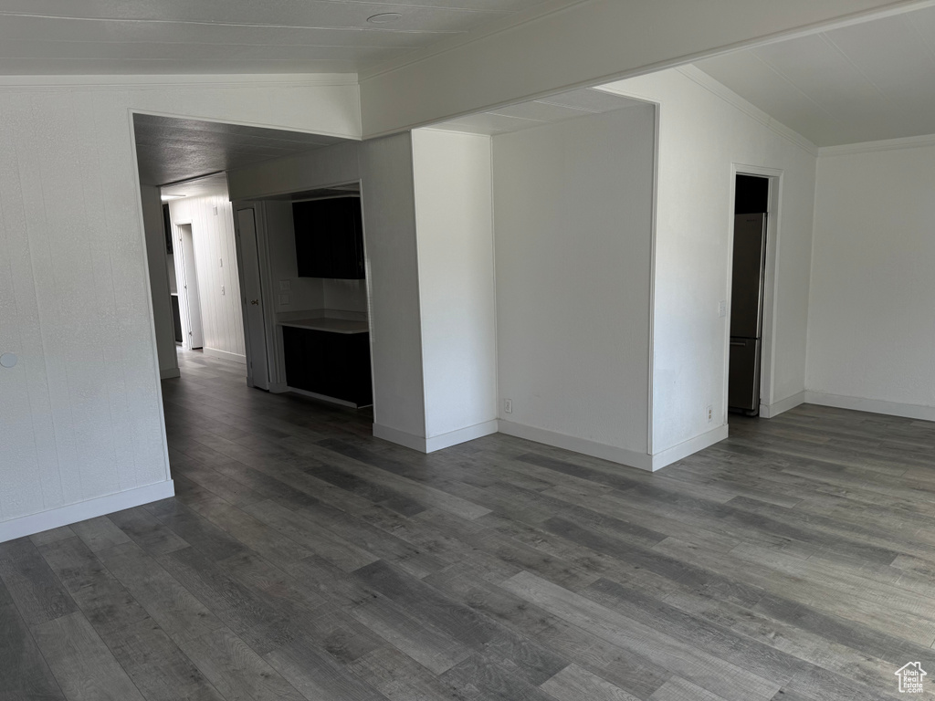 Unfurnished room with crown molding and dark wood-style flooring