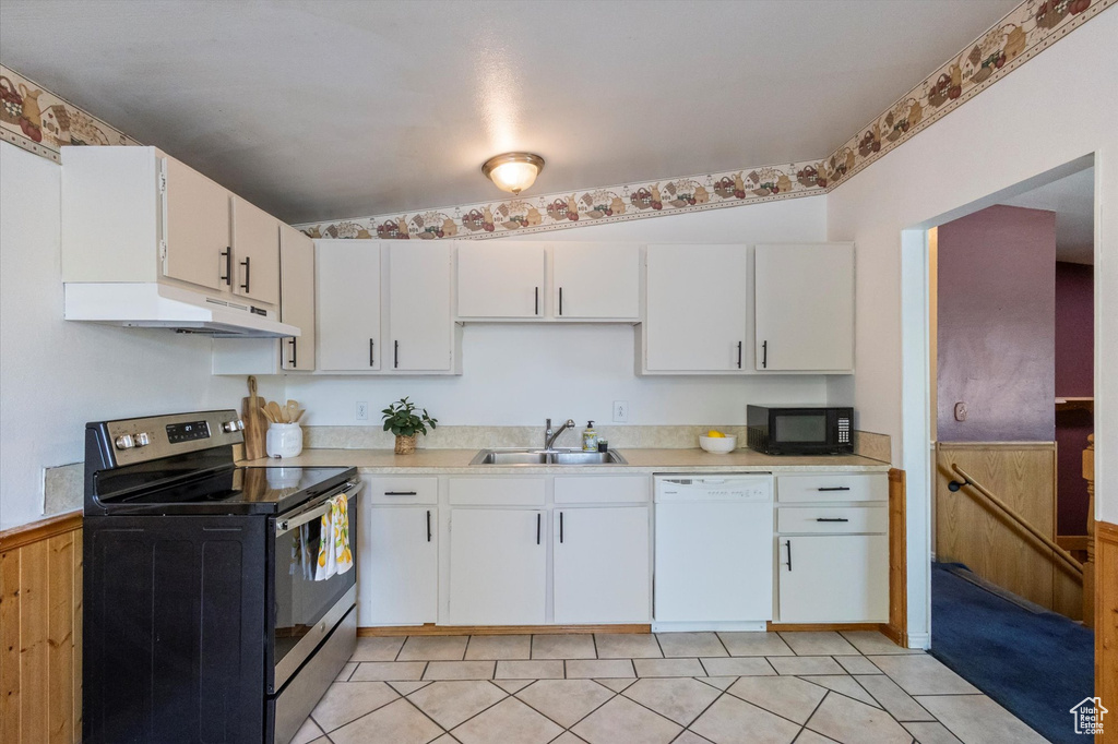 Kitchen featuring stainless steel range with electric stovetop, dishwasher, black microwave, under cabinet range hood, and light countertops