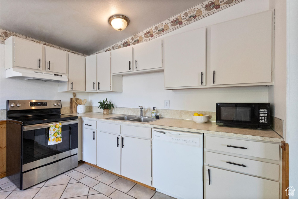 Kitchen featuring dishwasher, stainless steel electric stove, under cabinet range hood, black microwave, and light countertops