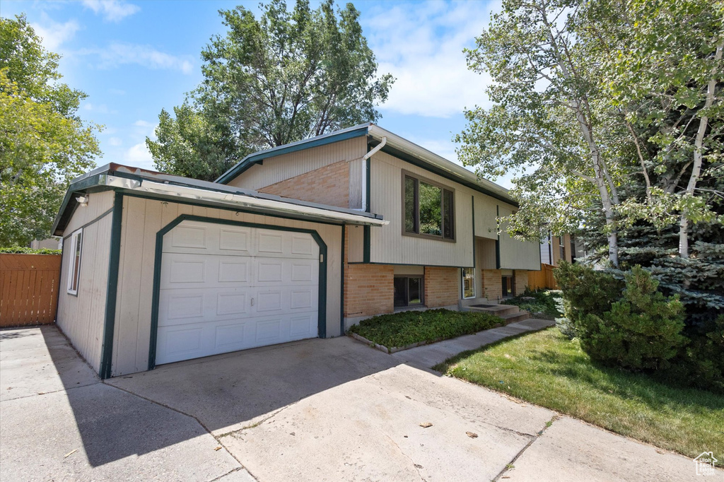 View of front of house featuring brick siding, an attached garage, and driveway