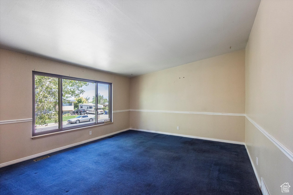 Empty room with dark carpet and baseboards