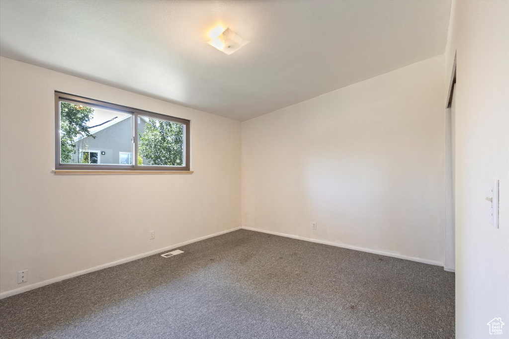 Spare room featuring carpet floors and baseboards