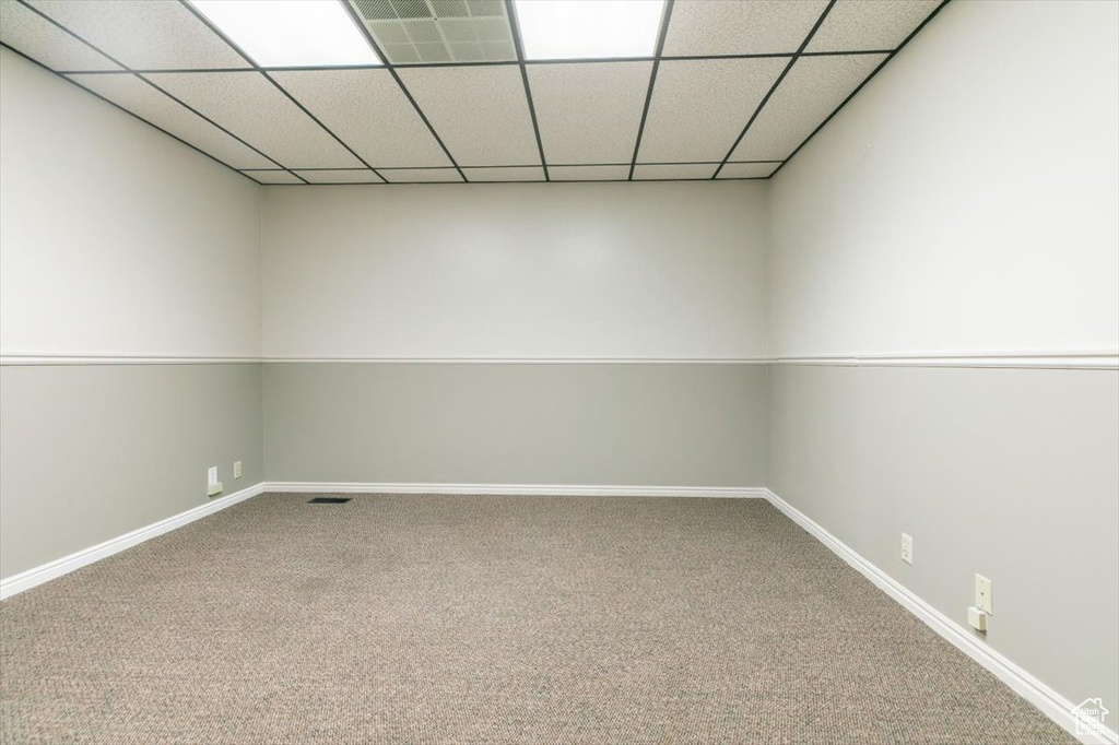 Carpeted empty room with baseboards and a paneled ceiling