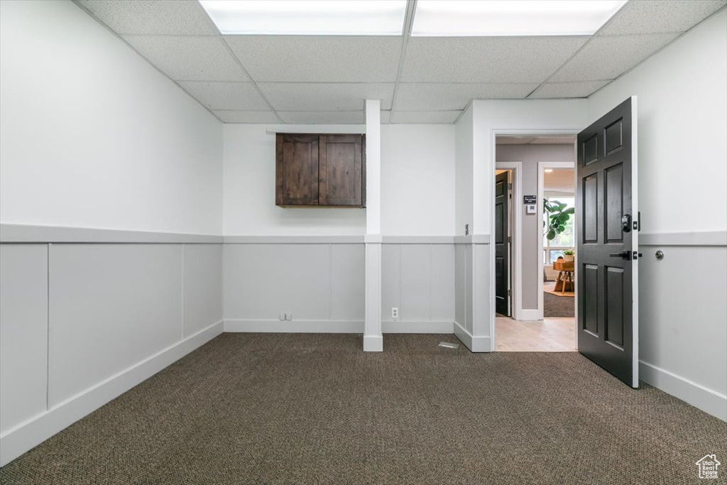 Basement with carpet floors and a drop ceiling