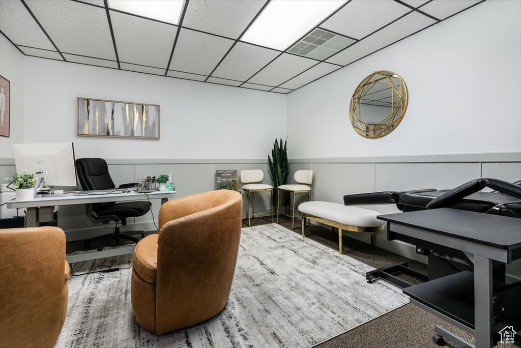 Carpeted office space with a drop ceiling
