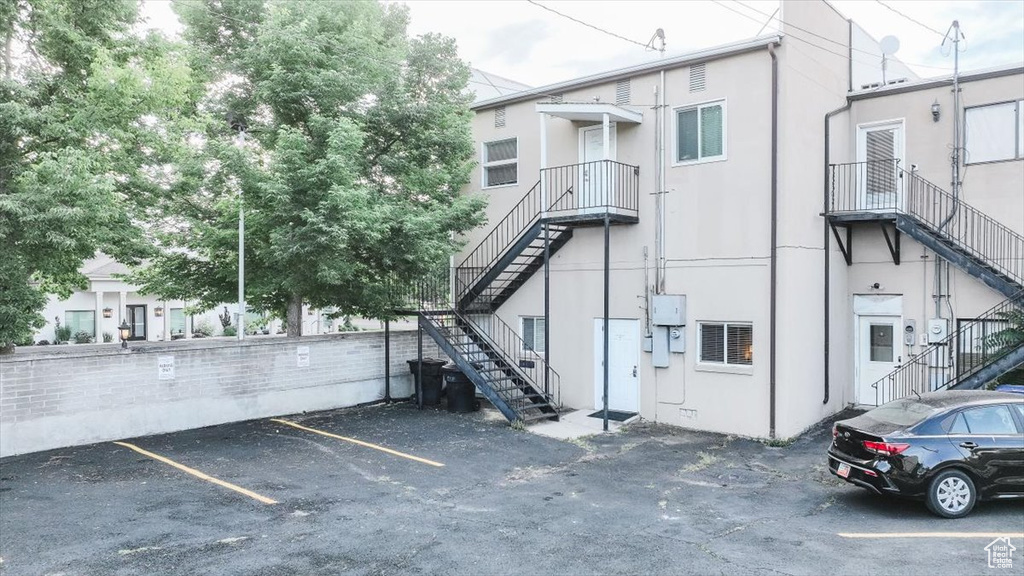 View of building exterior with stairway and uncovered parking