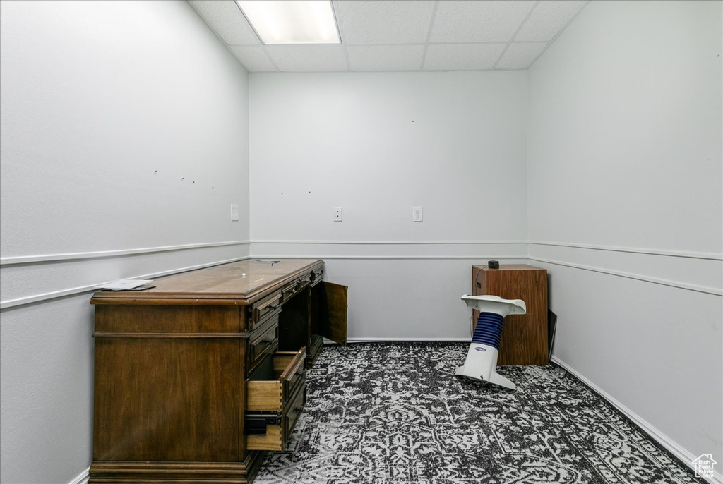 Unfurnished office with a paneled ceiling and baseboards