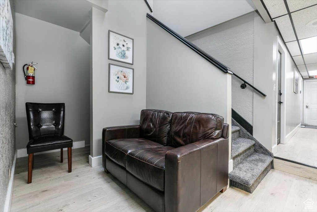 Living area with light wood finished floors, stairs, and a textured wall