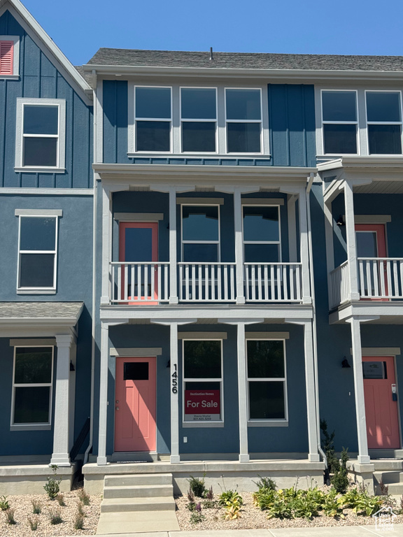 Traditional home featuring board and batten siding, a balcony, and entry steps