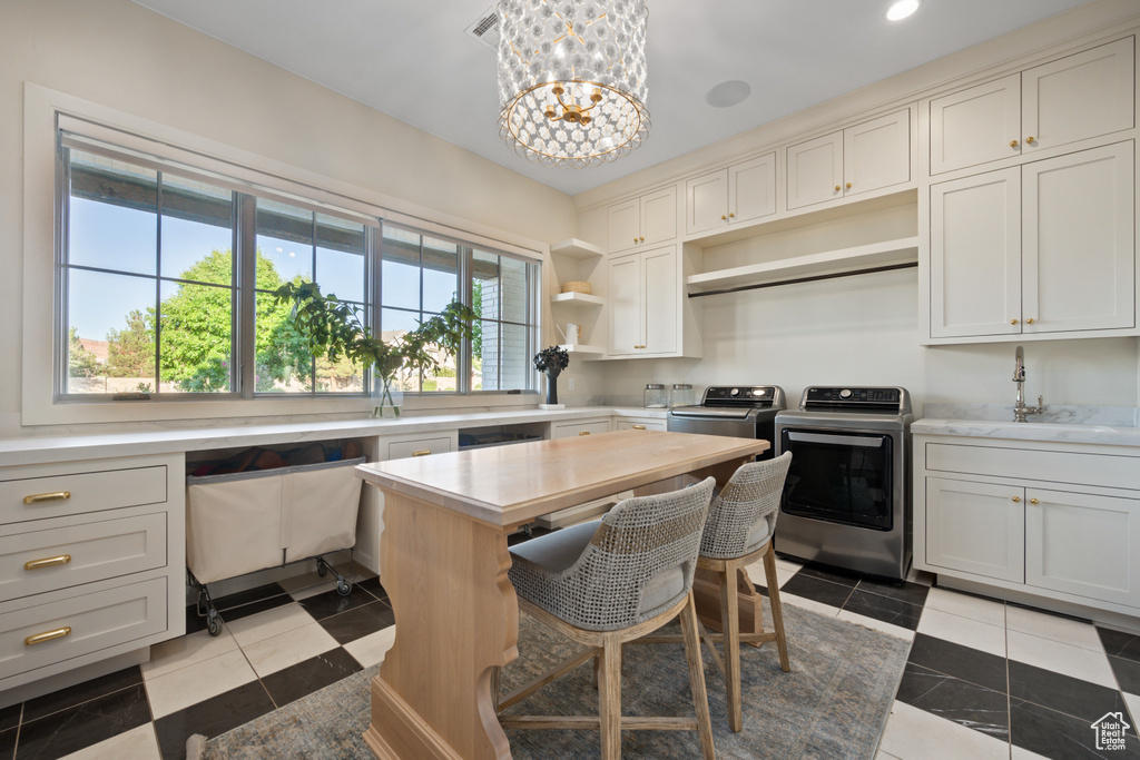 Kitchen with washer and clothes dryer, open shelves, light countertops, a chandelier, and recessed lighting