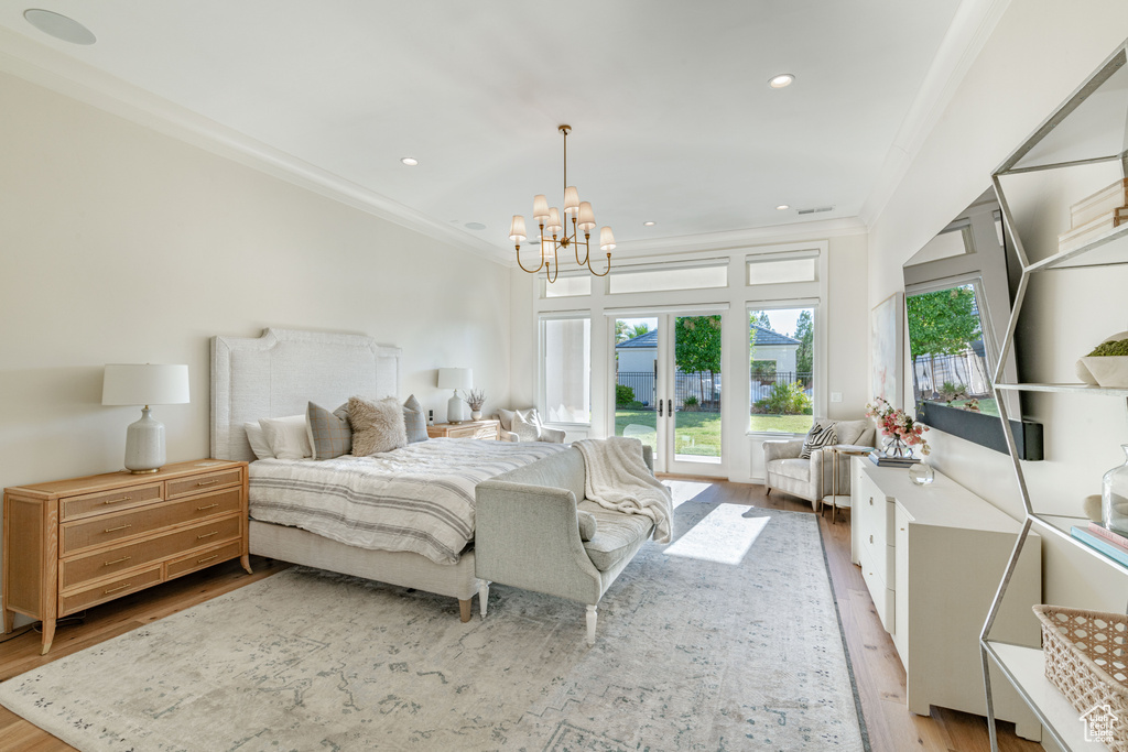 Bedroom with access to outside, wood finished floors, multiple windows, ornamental molding, and french doors