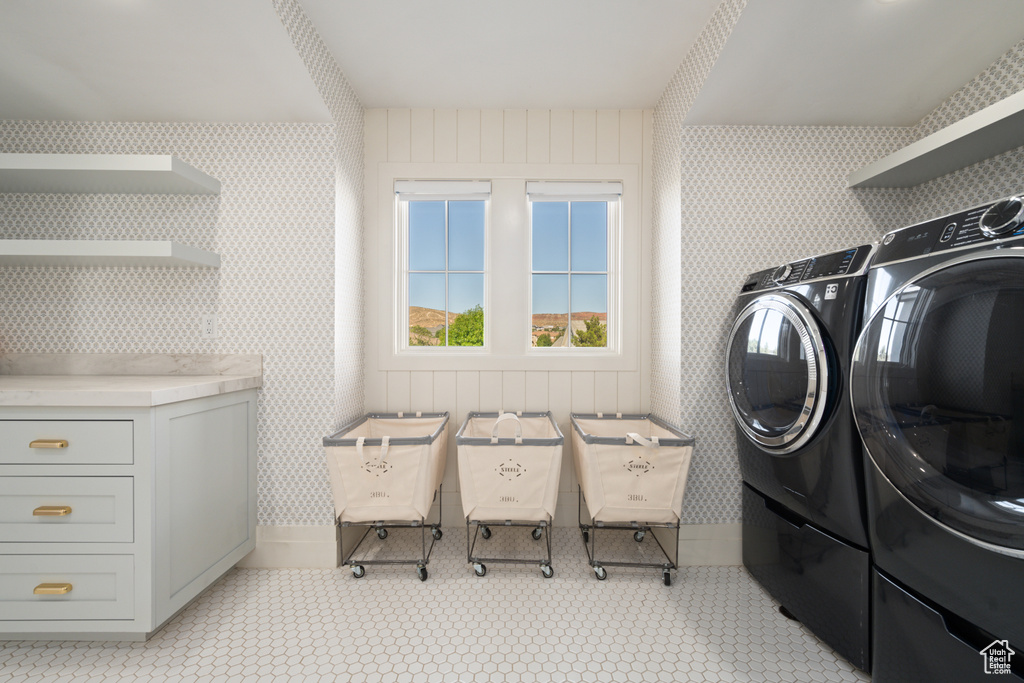 Laundry area with wallpapered walls and washing machine and dryer