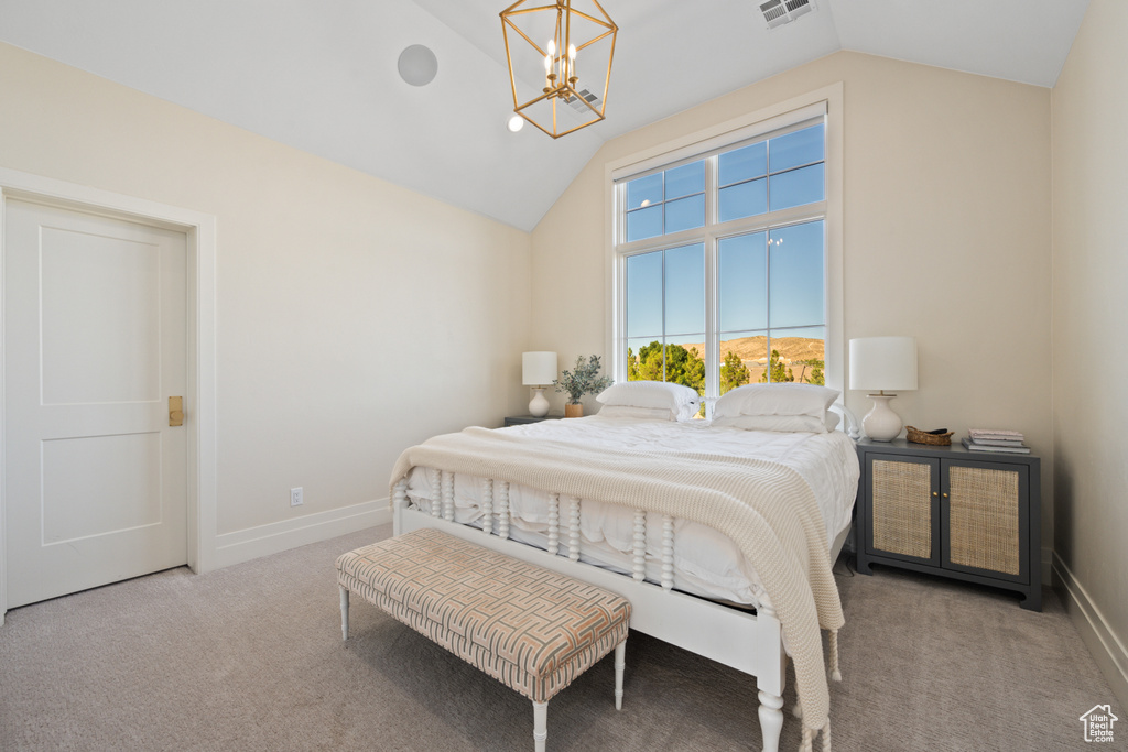 Bedroom with vaulted ceiling, carpet, and a chandelier