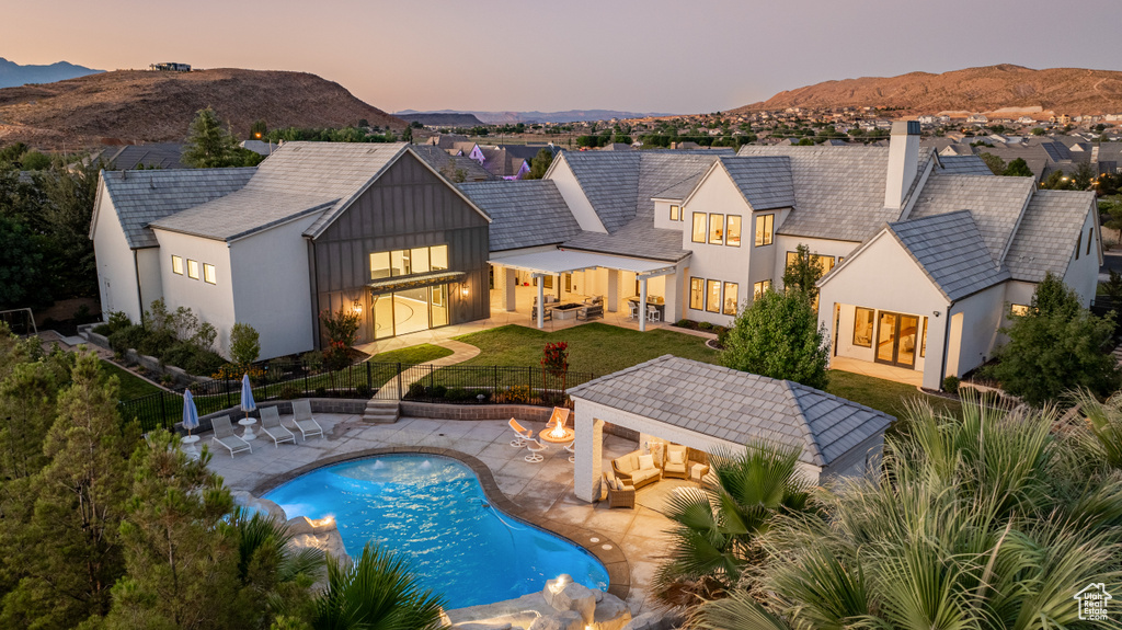 Rear view of house with outdoor lounge area, a fenced backyard, a gazebo, a mountain view, and a patio area