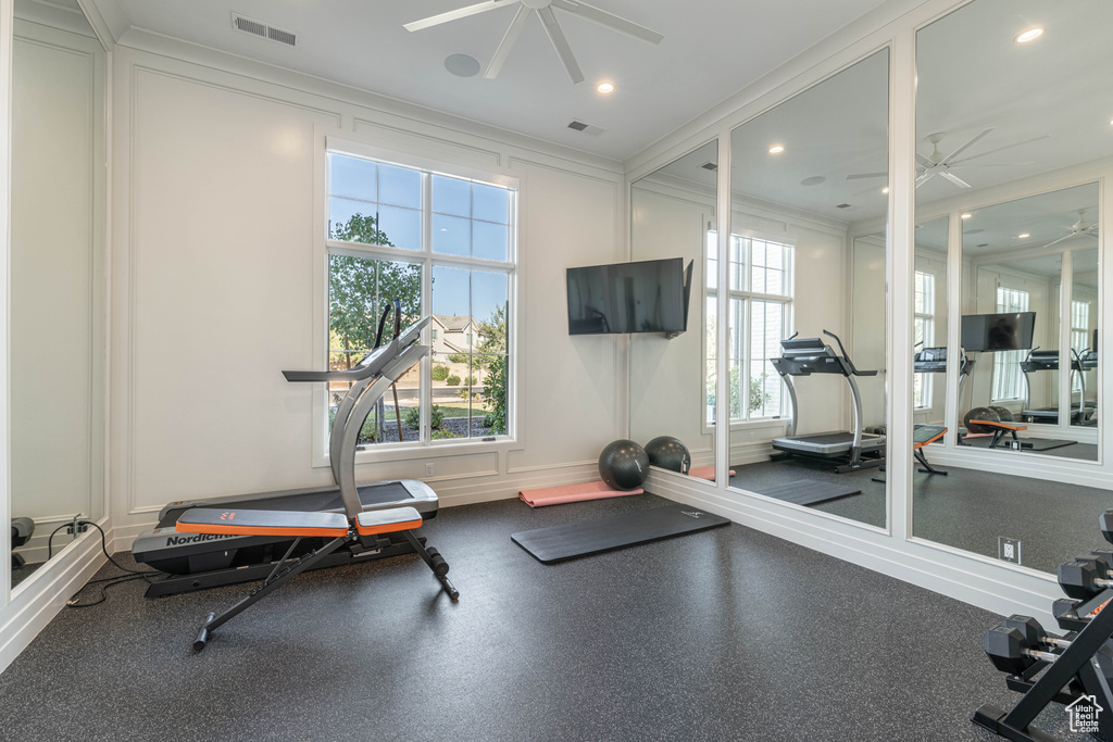 Workout area with a ceiling fan, crown molding, healthy amount of natural light, a decorative wall, and recessed lighting