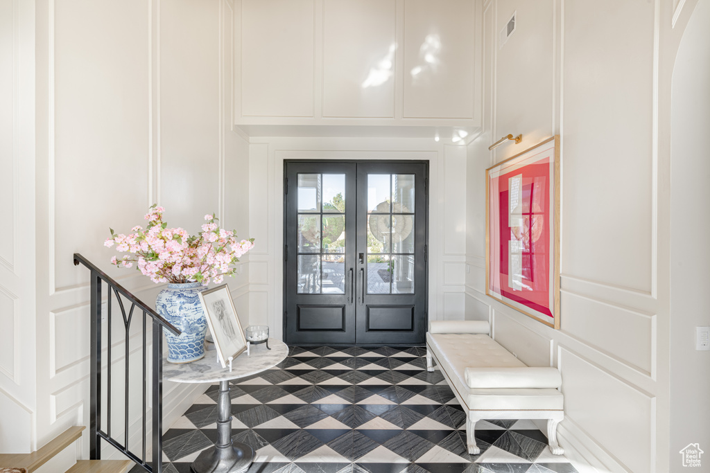 Foyer entrance with a decorative wall and french doors