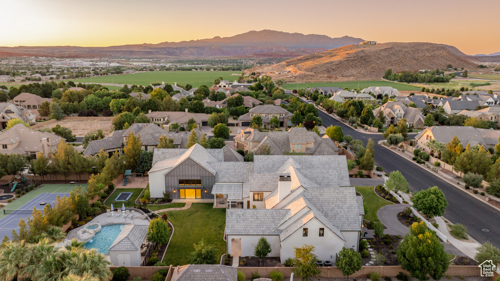 Aerial view at dusk of a mountain view and view of pool