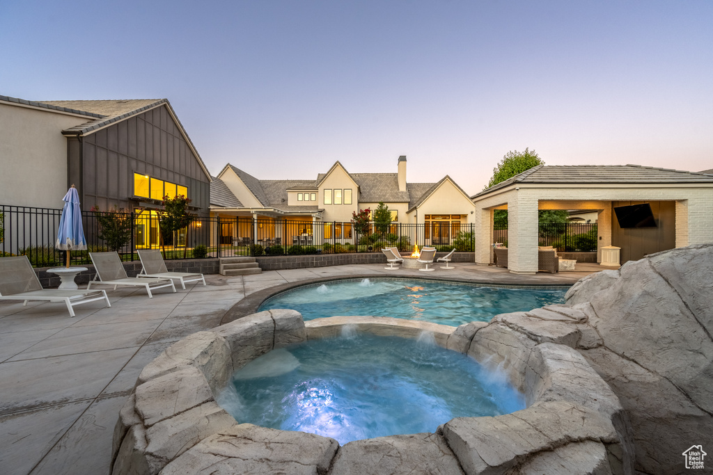 View of swimming pool with a pool with connected hot tub and a patio