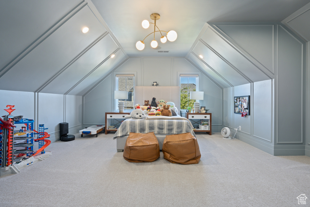 Carpeted bedroom featuring a decorative wall and lofted ceiling