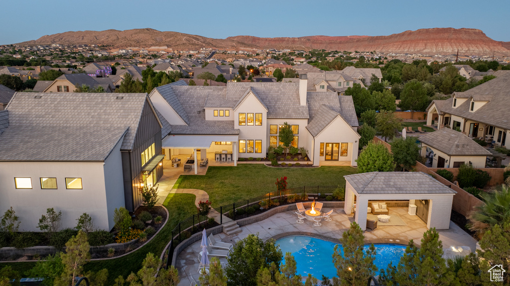 View of pool with a fenced backyard, a mountain view, an outdoor structure, and a residential view