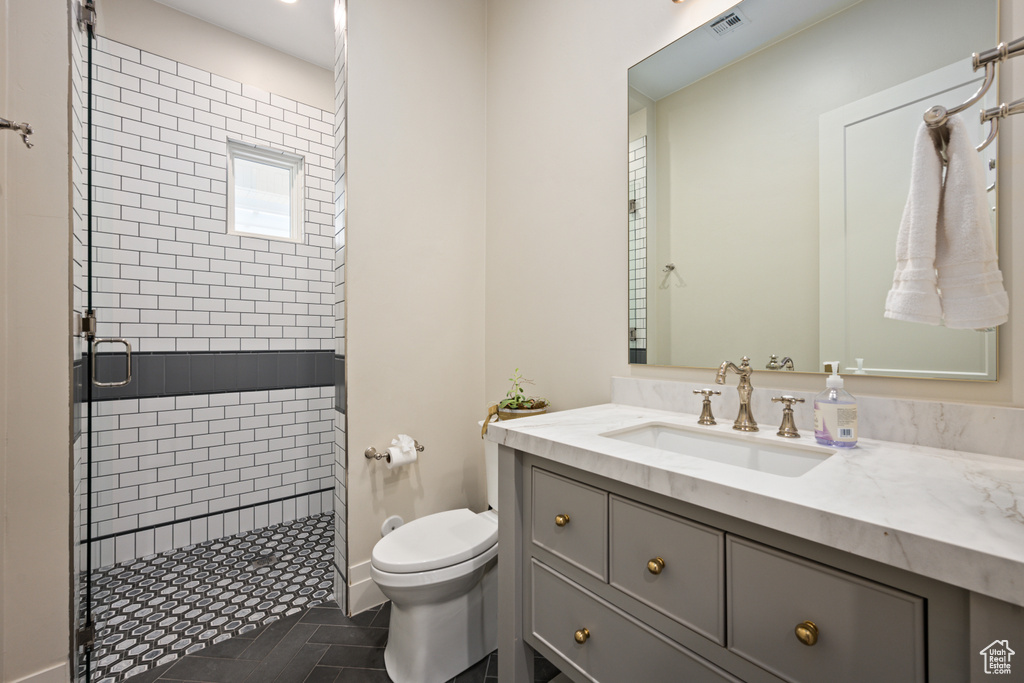 Bathroom featuring a shower stall, vanity, and tile patterned flooring