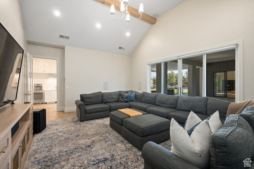 Living area featuring high vaulted ceiling, light wood-type flooring, beamed ceiling, and recessed lighting