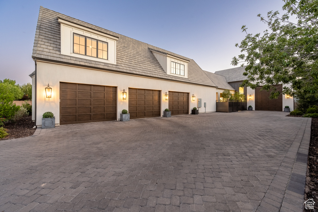 View of front facade featuring decorative driveway and stucco siding