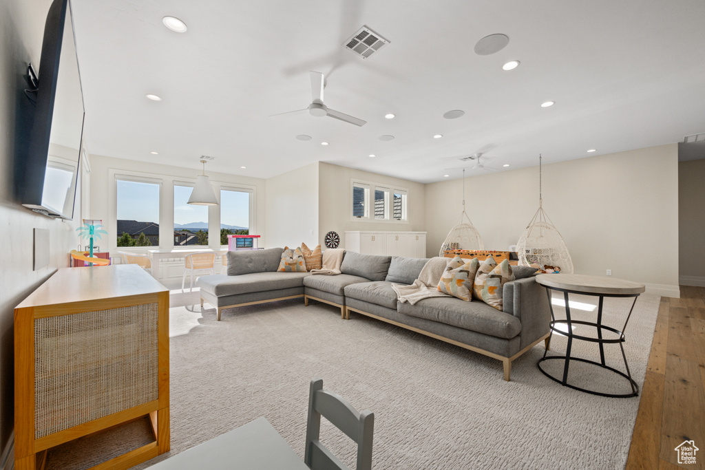 Living area with ceiling fan, recessed lighting, and light colored carpet