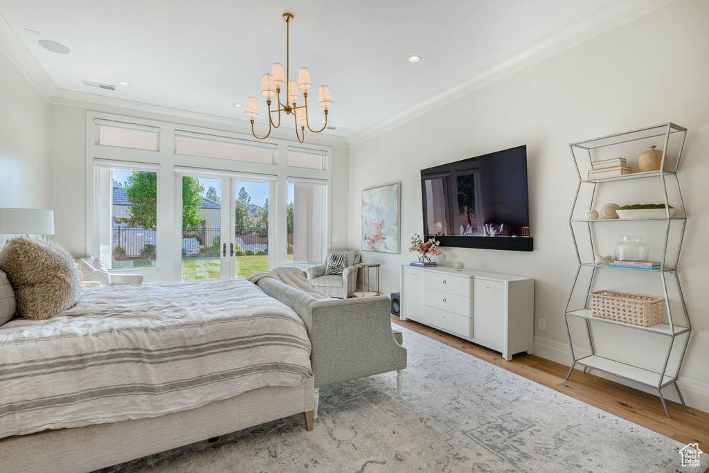 Bedroom featuring ornamental molding, french doors, a chandelier, light wood finished floors, and access to exterior