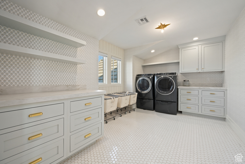 Laundry room featuring washer and clothes dryer, cabinet space, and recessed lighting