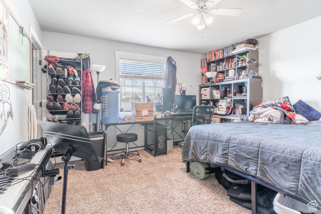 Carpeted bedroom with a ceiling fan
