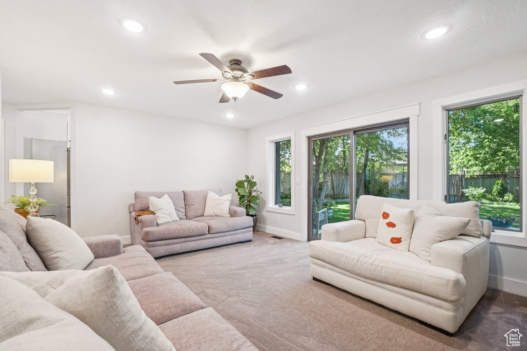 Carpeted living room with plenty of natural light, recessed lighting, and ceiling fan