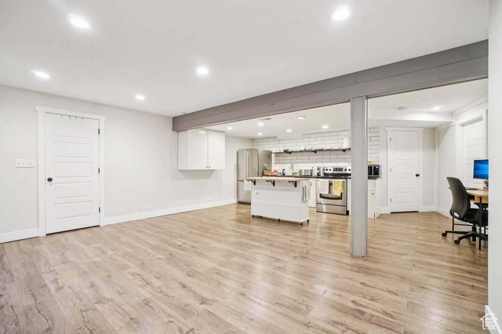 Living area with recessed lighting, light wood finished floors, and a desk