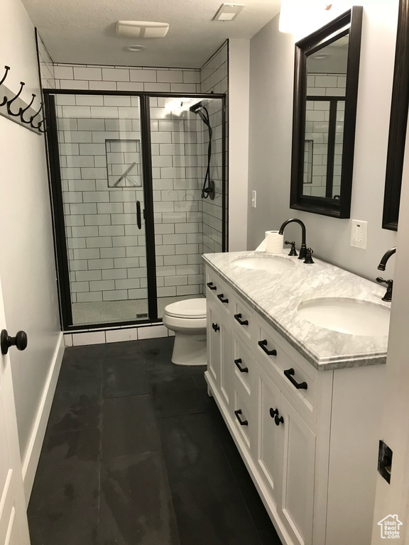 Full bathroom with double vanity, a stall shower, and tile patterned floors