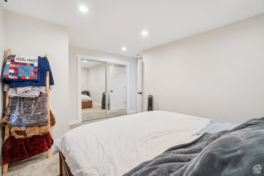 Bedroom with light carpet, recessed lighting, and a closet