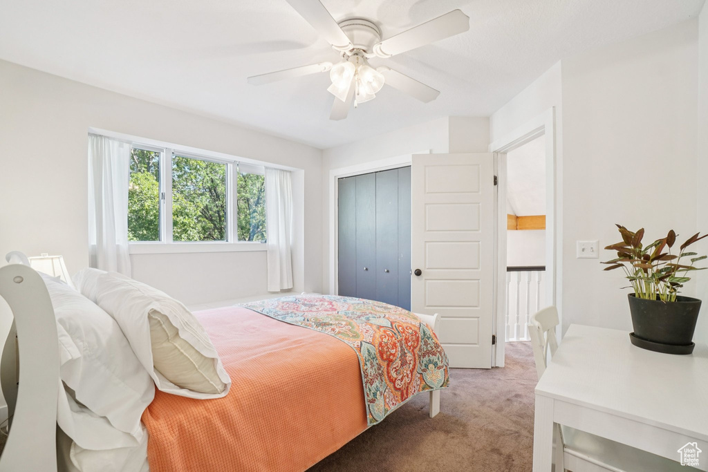 Bedroom featuring light colored carpet, a closet, and ceiling fan