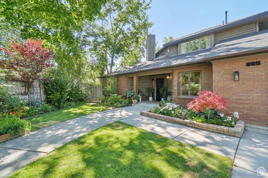 View of front of property with a chimney and brick siding